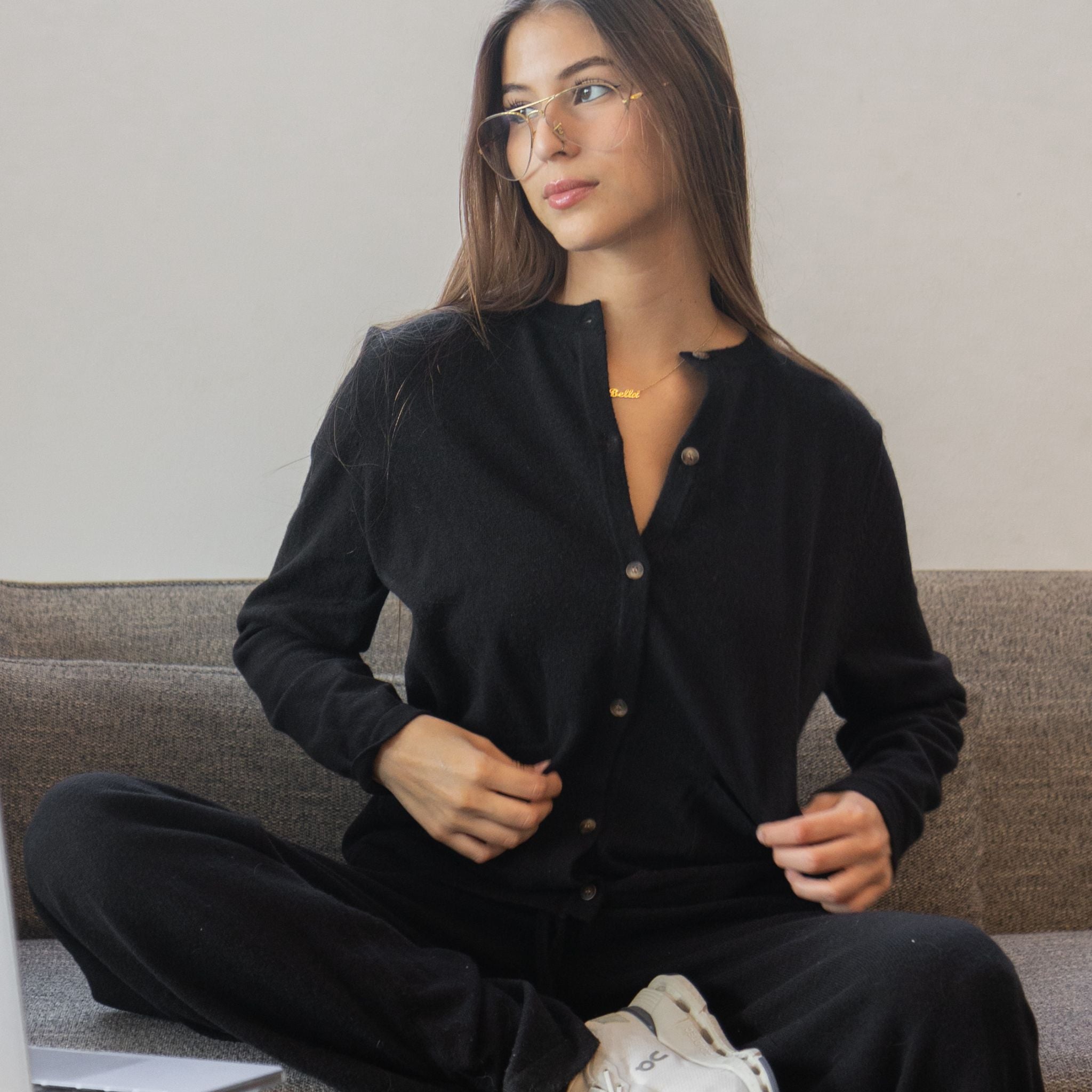 woman wearing button up cardigan sitting on couch